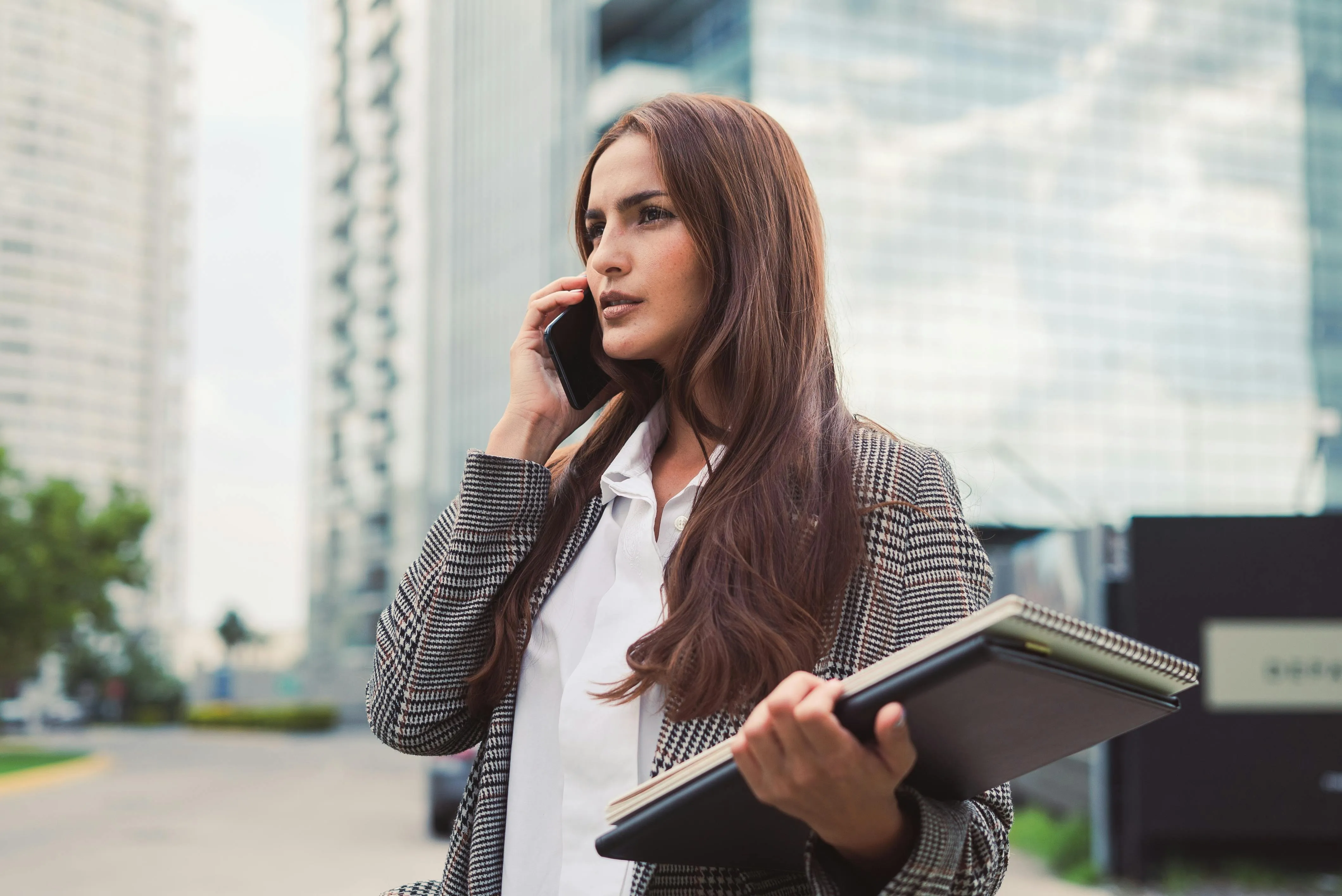 Mujer ejecutiva hablando por celular en la calle