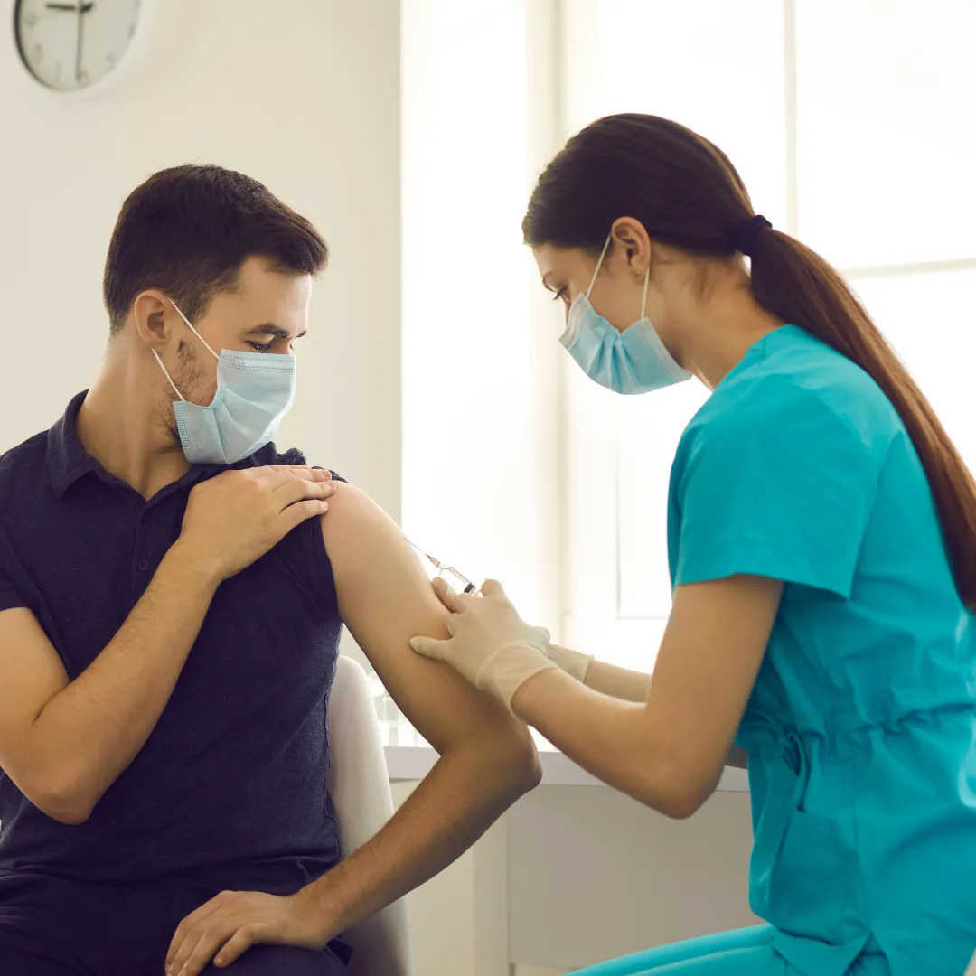 personal de salud vacunando a una persona en un consultorio